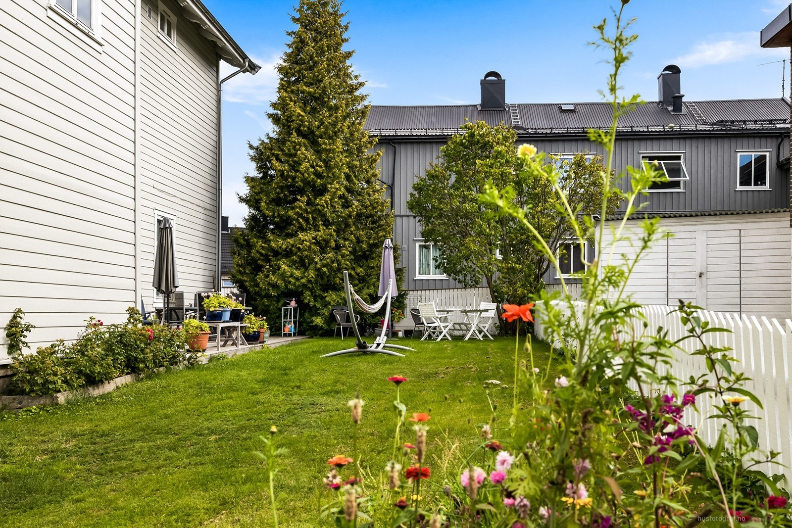 Opparbeidet nyere terrasseplatting med felles sittemøblement og grill Galleribilde