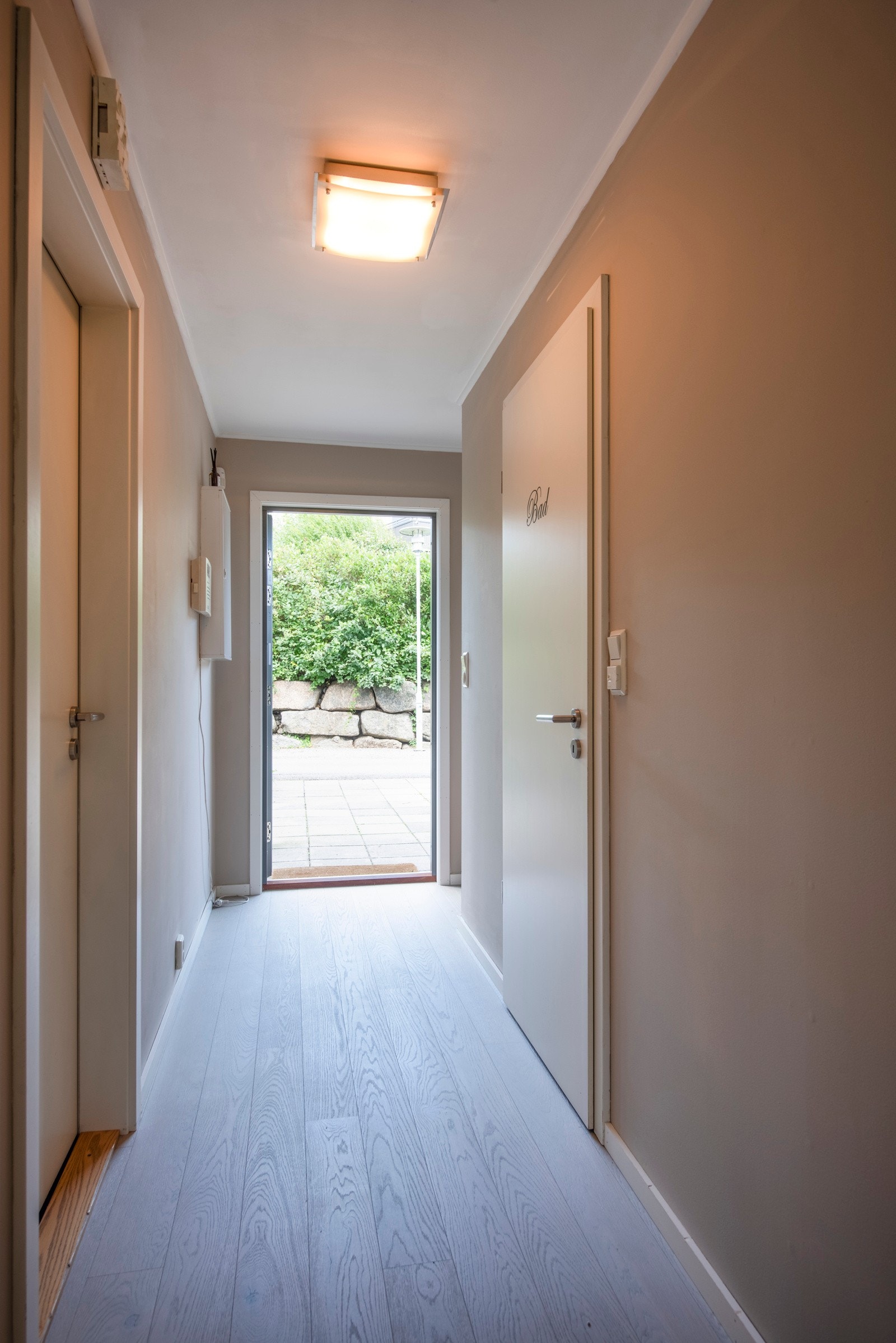 Inne har leiligheten en gang i direkte tilknytning til stuen, med det samme fine og lyse 1-stavs parkettgulvet. Veggene er beige, og i gangen passer det fint å innrede med knagger og skohyller. Galleribilde