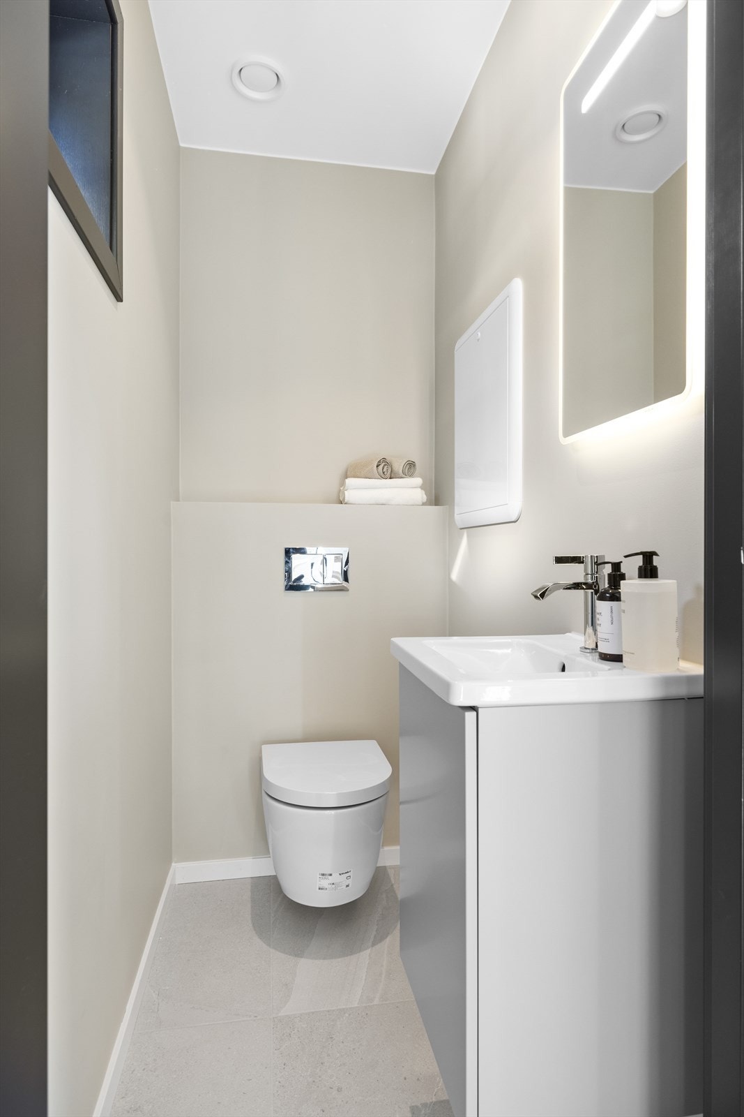 Separat wc-rom/gjestetoalett i 1. etasje med flislagt gulv og malte veggflater. Varmekabler i gulv og downlights i himling Galleribilde