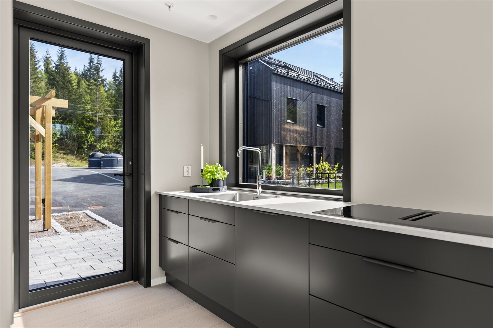 Kjøkkenet får masse lys fra store vindusflater og har direkte utgang terreng, en fin uteplass med belegningsstein Galleribilde