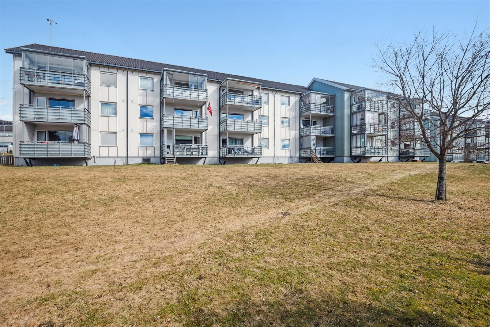 Veranda vender mot et rolig fellesområde, opparbeidet med plenarealer. Galleribilde