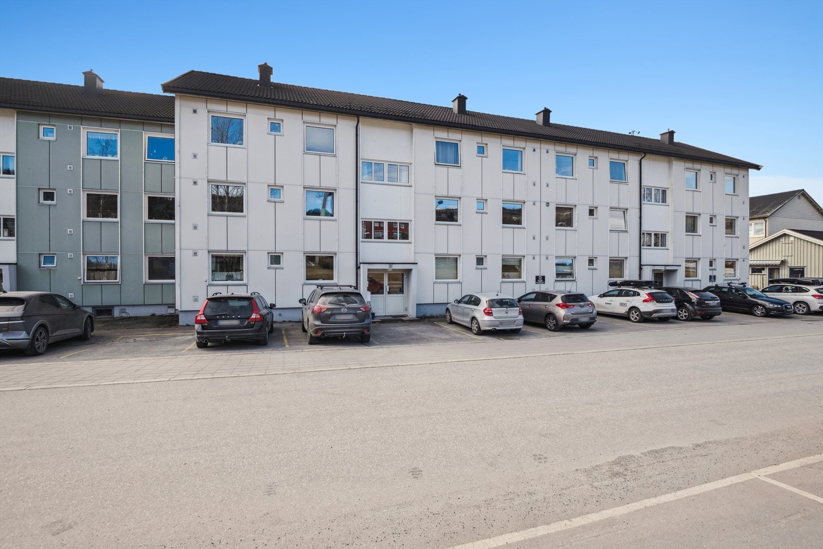 Det er felles parkering i front av blokka. Galleribilde