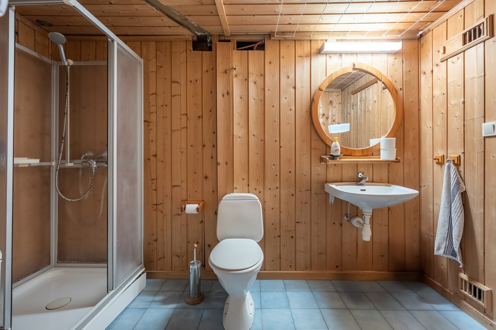 Originalt baderom med flislagt gulv, gulvvarme, panel på vegger og i himling. Galleribilde