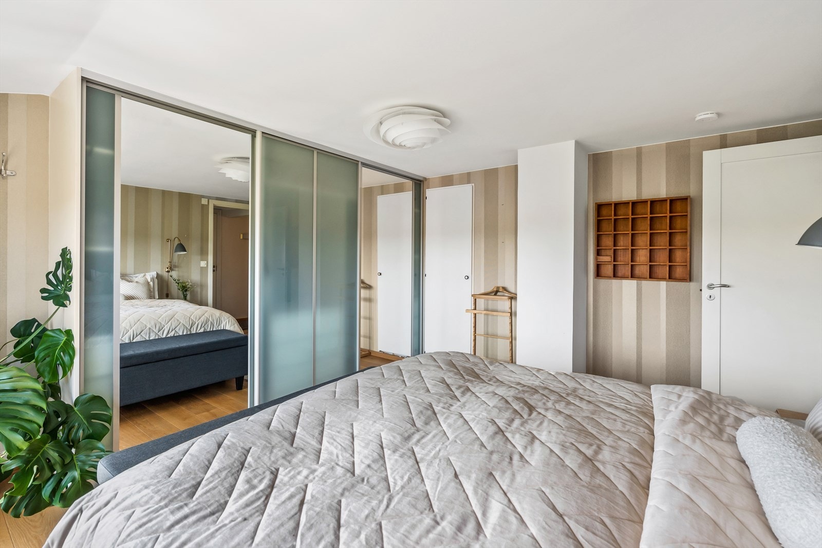 Det er rikelig med lagringsplass i stor skyvedørsgarderobe langs den ene veggen. Galleribilde