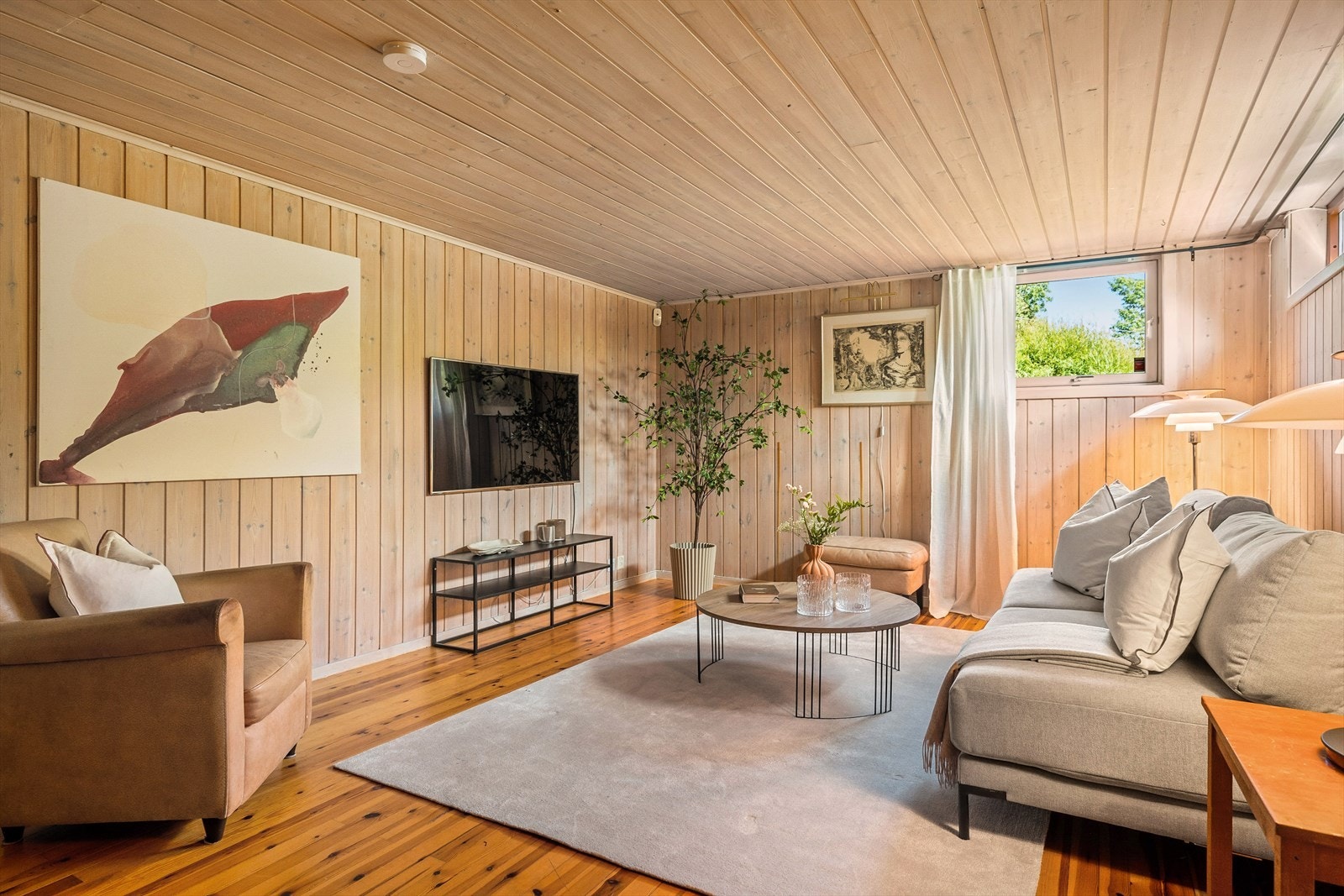 Boligen har en hyggelig kjellerstue med plass til sofagruppe, tv, bokhyller og lesekrok . Galleribilde