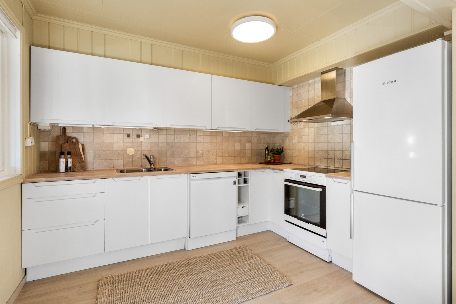 Lyst og funksjonelt kjøkken med integrerte hvitevarer og god skapplass. Galleribilde