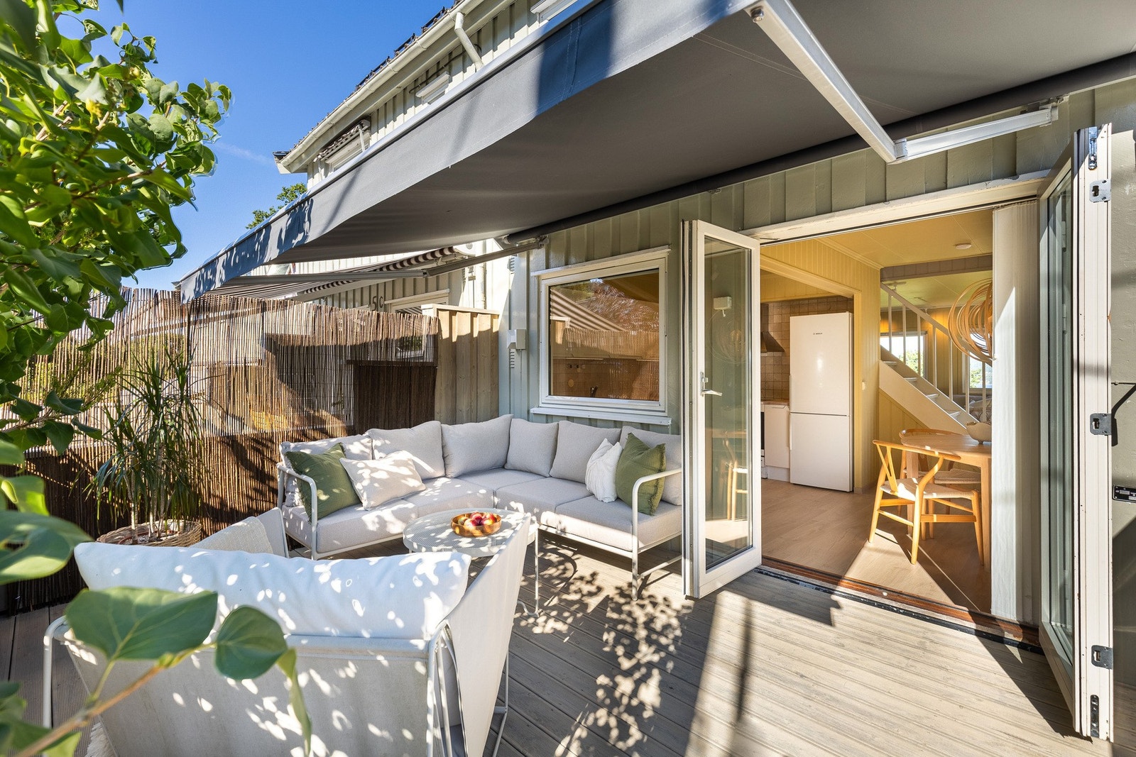 Terrasse med sitteplass, markise og direkte utgang fra kjøkken. Galleribilde