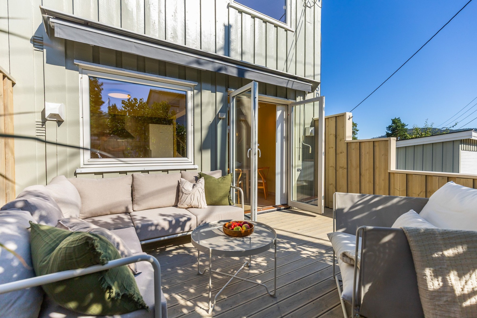 Lys og solrik terrasse med plass til sittegruppe og bord. Galleribilde