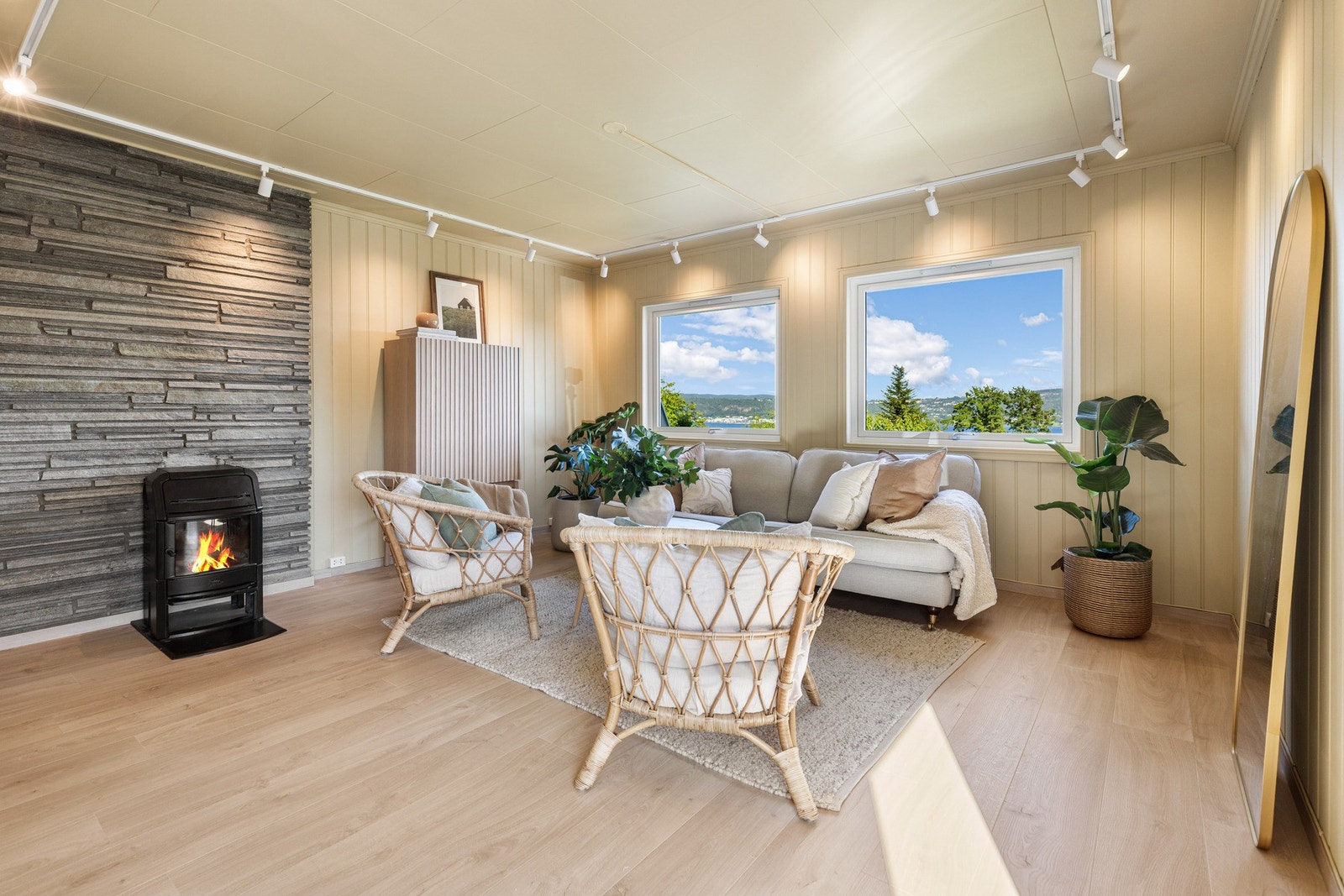 Lyst rom med store vinduer, peis og pen parkett. Galleribilde