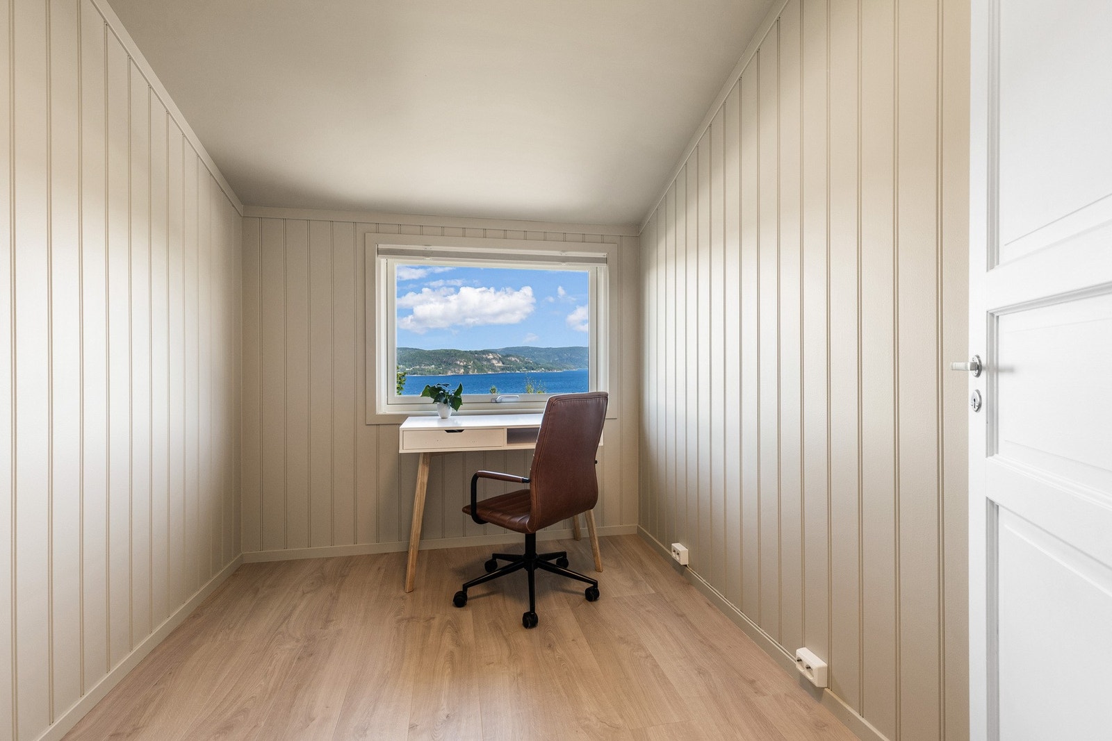 Lyst rom med store vinduer og flott utsikt over vann og landskap. Galleribilde