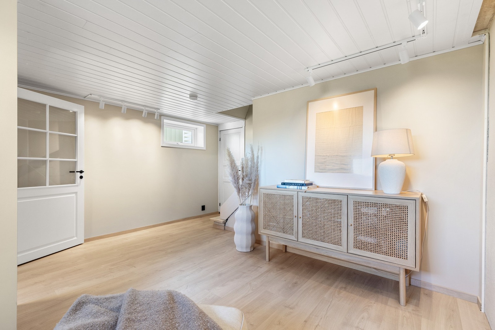 Romslig og lyst rom med hvitt paneltak og lyse vegger. Galleribilde