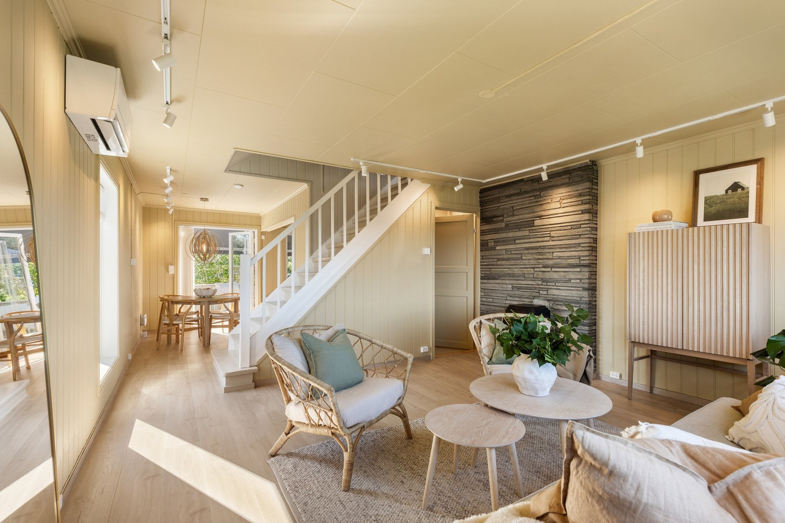 Lys og romslig stue med store vinduer og åpen løsning mot spisesone. Galleribilde