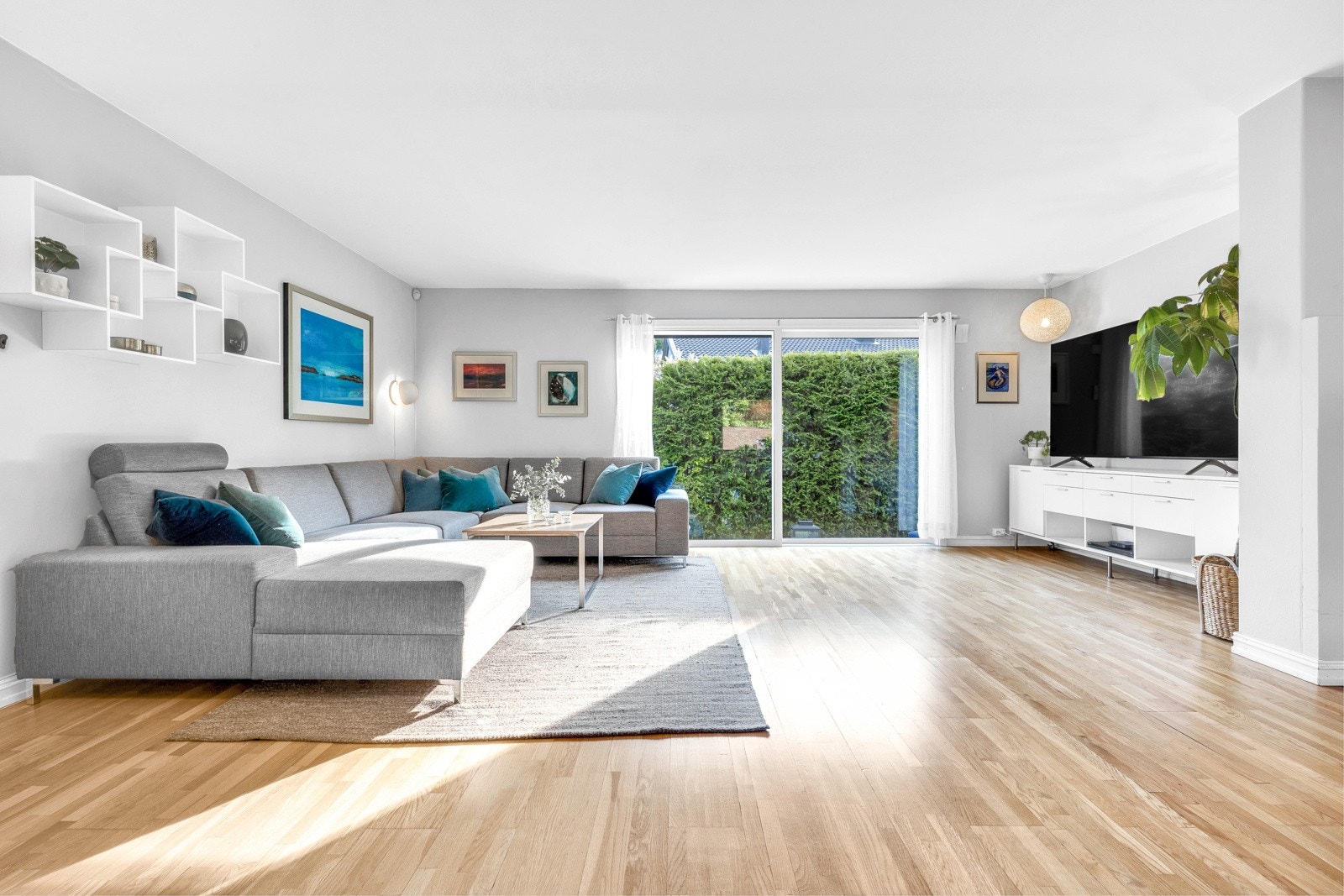 Det er brede skyvedører i glass ut til terrassen, og om sommeren er det deilig å åpne helt opp slik at skillet mellom inne og ute fjernes. Galleribilde