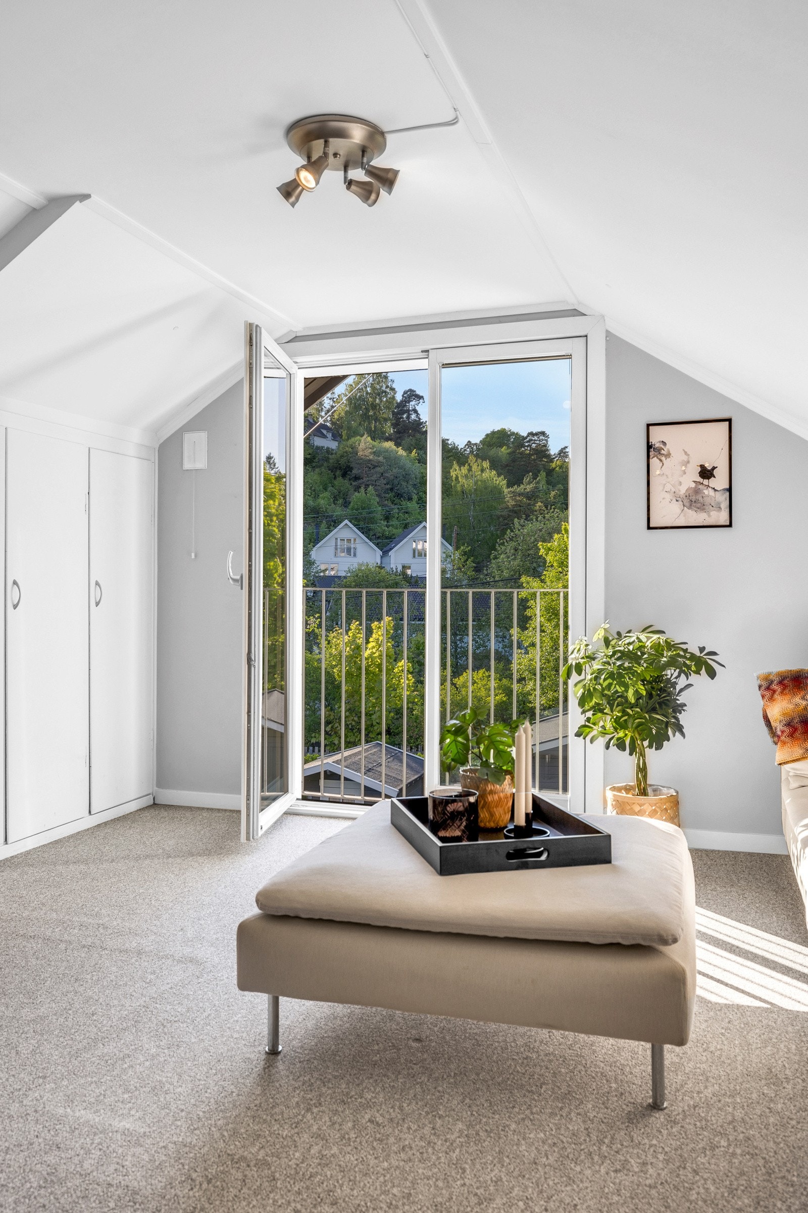 Gulvet har vegg-til-vegg teppe, veggene er gråmalte og himlingen har sjarmerende skråtak. Galleribilde