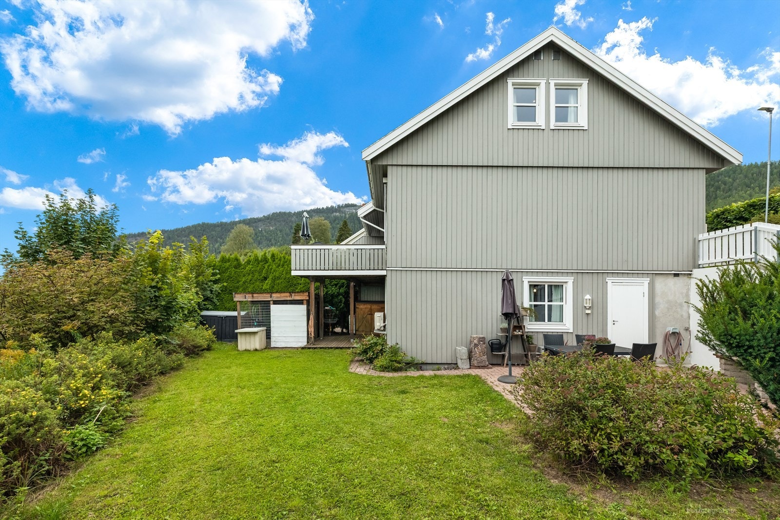 Tomten er pent opparbeidet med gressplen, beplantninger samt noe prydbusker. Galleribilde