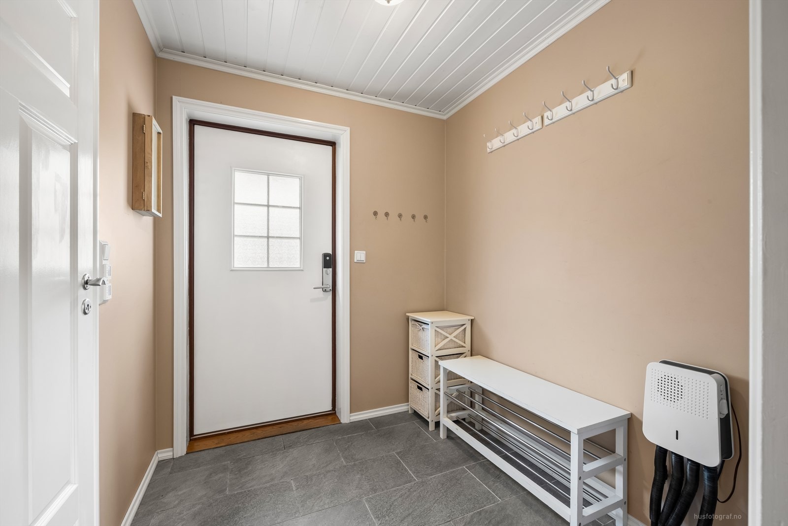 Velkommen inn! Til en gang med fliser og knagger til oppbevaring av tøy. Fra gang er det lett adkomst til gjeste toalett, døren til venstre på bilde. Galleribilde