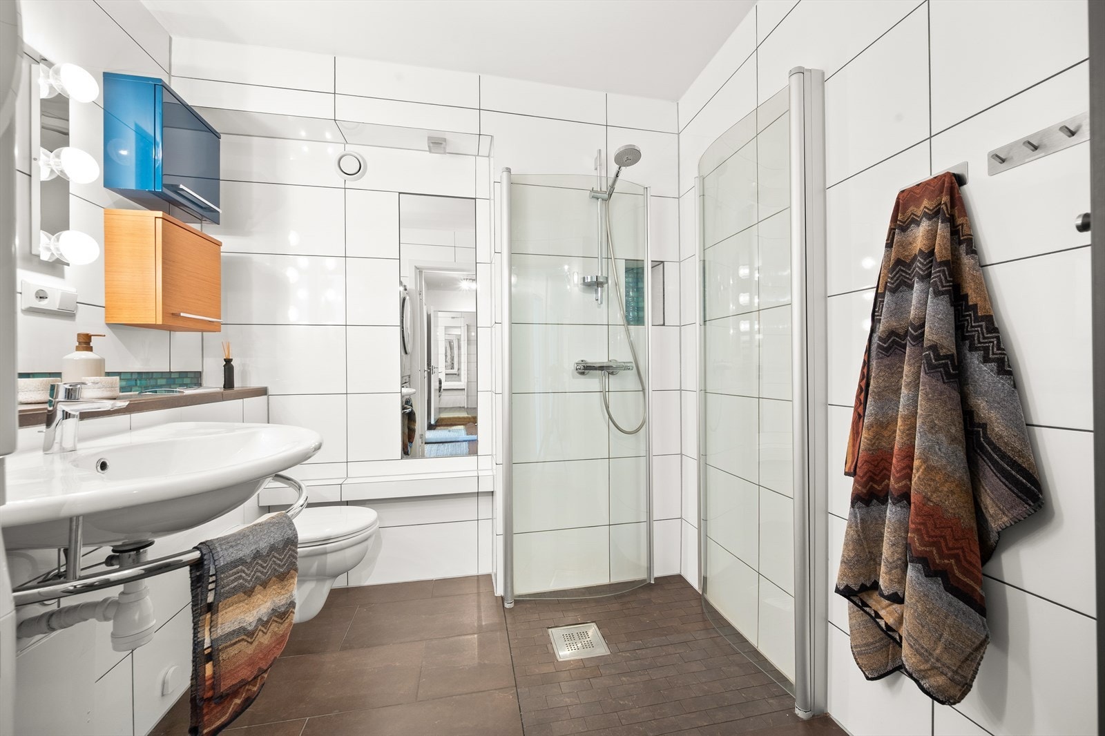 Rommet er innredet med vegghengt toalett, servant
og dusjhjørne med svingbare glassdører. Galleribilde