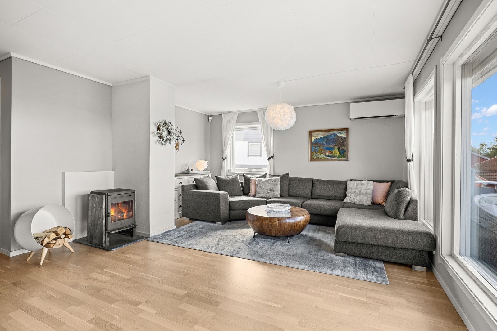 Leiligheten har en romslig og innbydende stue med store vindusflater som slipper inn rikelig med naturlig lys og gir en luftig atmosfære. Galleribilde