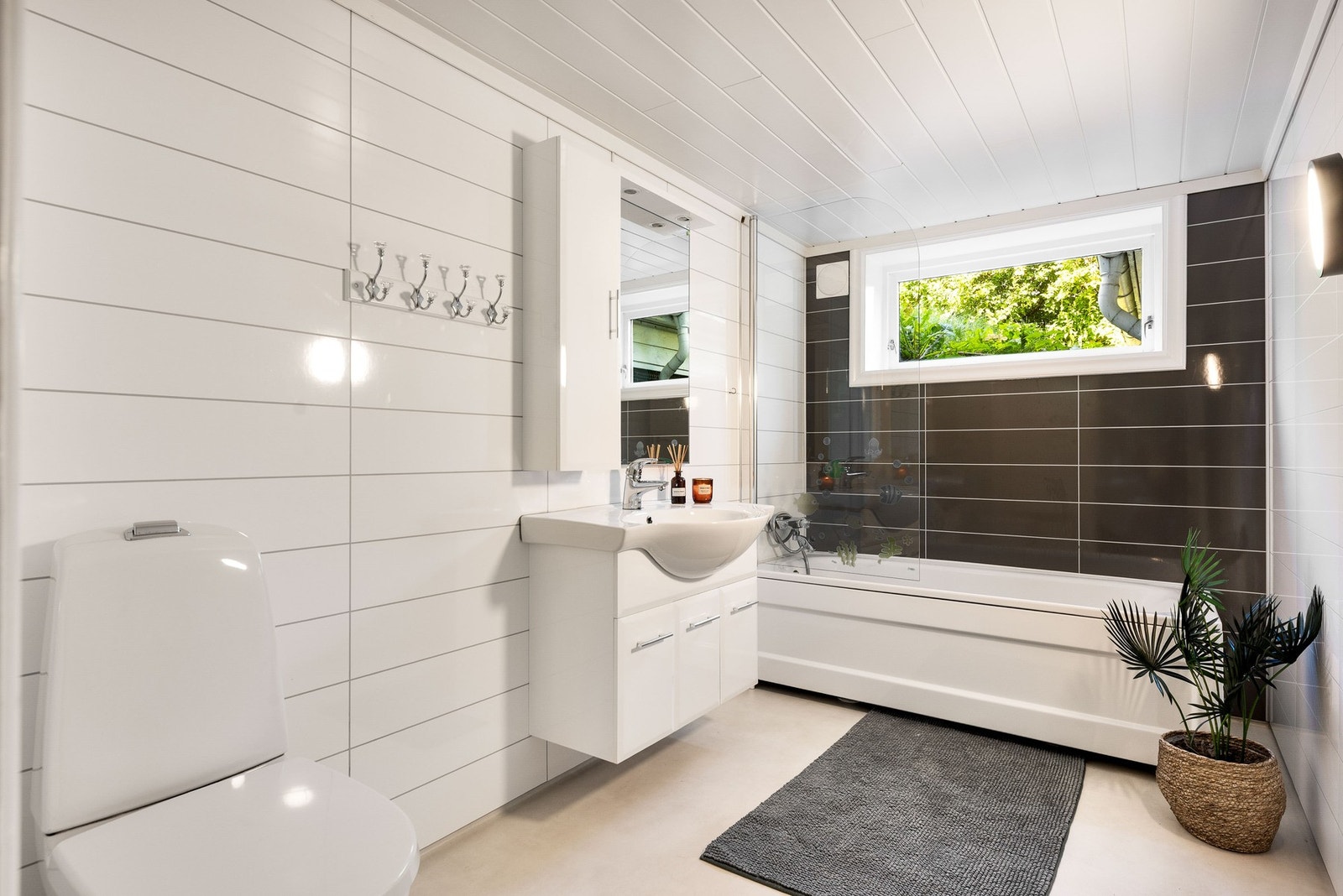 Baderom med badekar, servant og toalett. Galleribilde