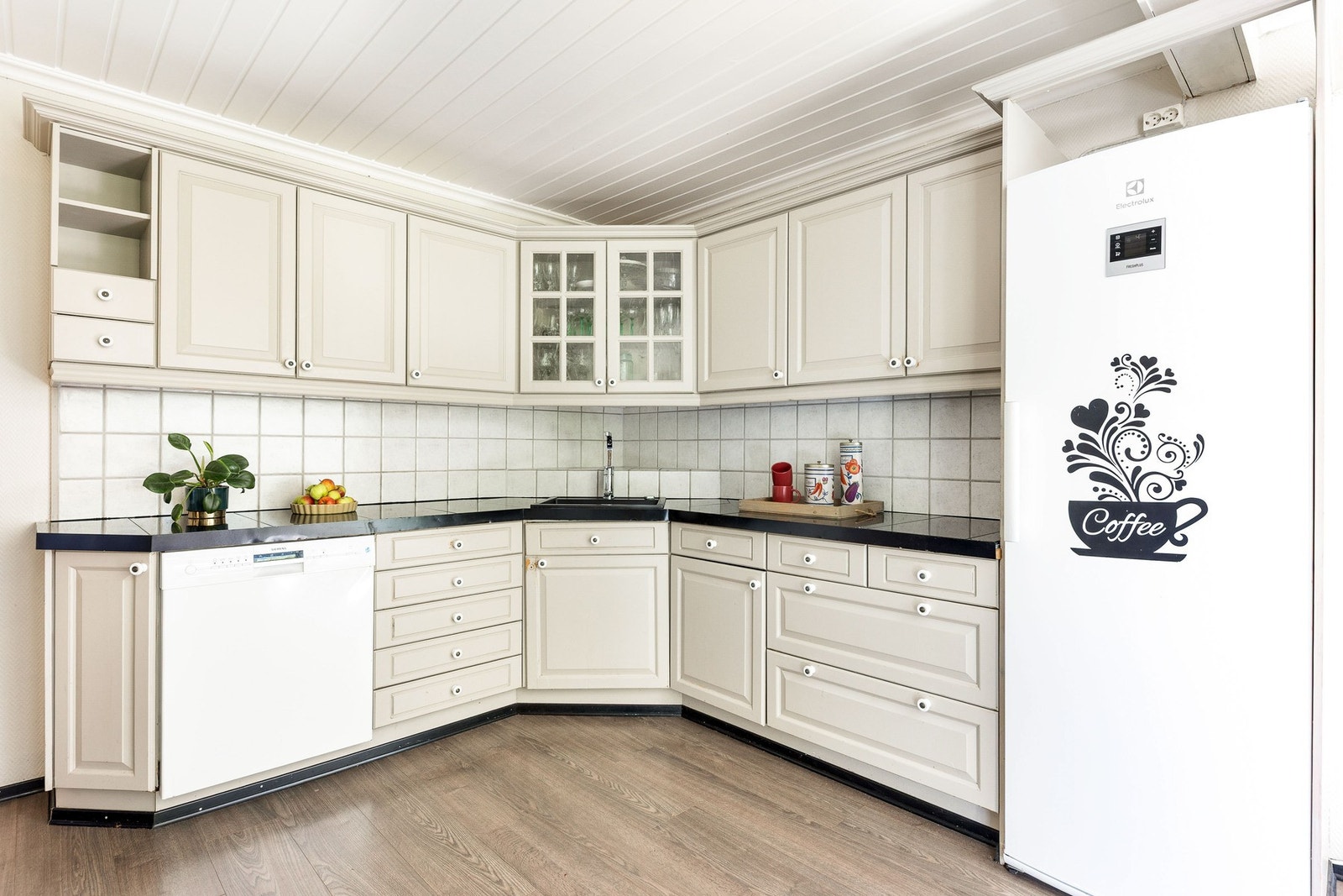 Kjøkkeninnredning med lyse overflater og mørk benkeplate. Galleribilde