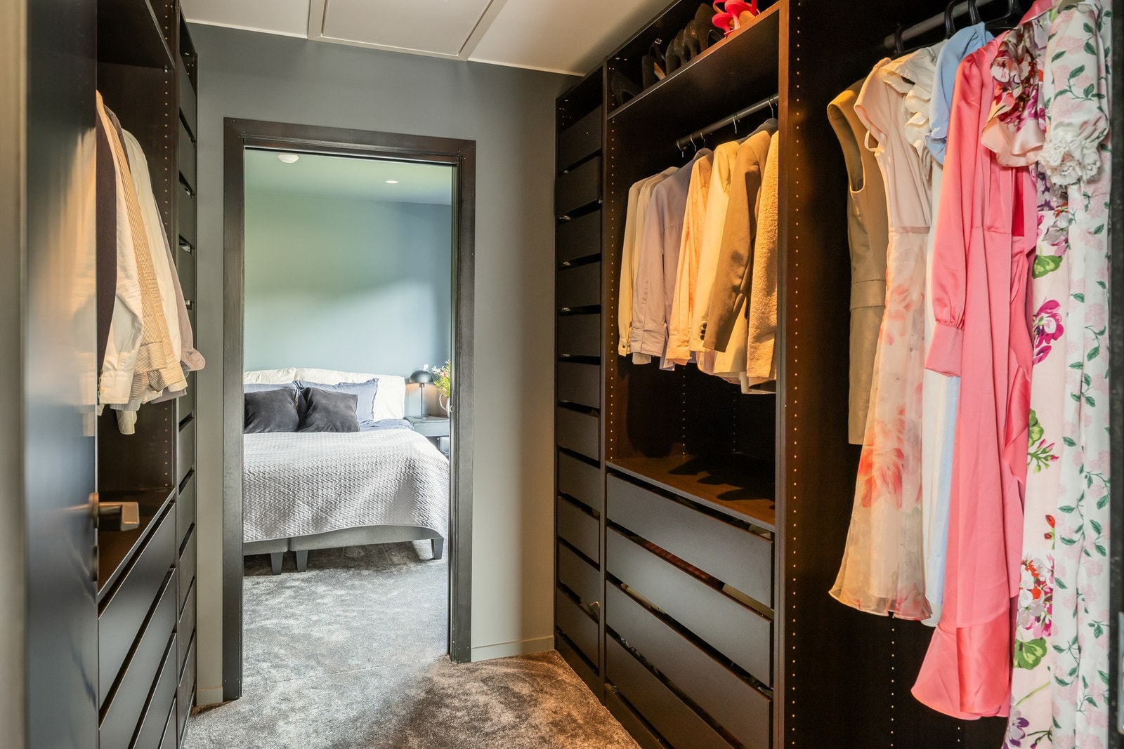 Man går gjennom garderoben hvor det er skap og skuffer på begge sider. Galleribilde