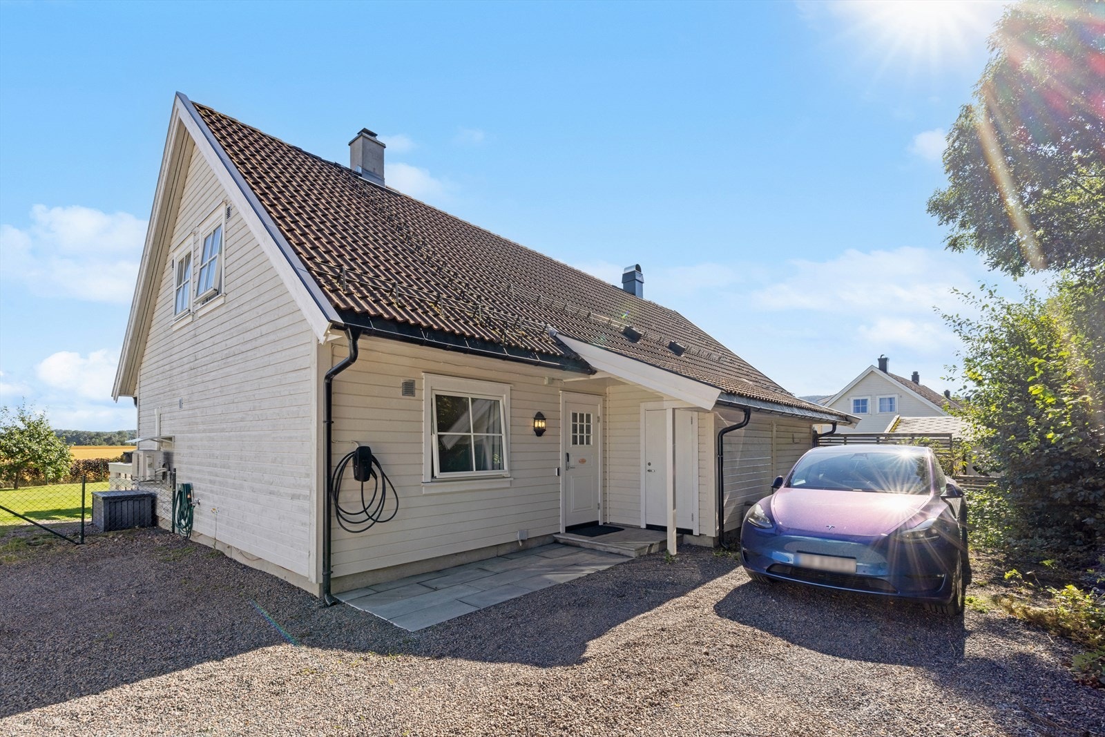 Det er god plass til parkering av flere biler i gårdsplassen. Elbillader er montert på husvegg. Galleribilde