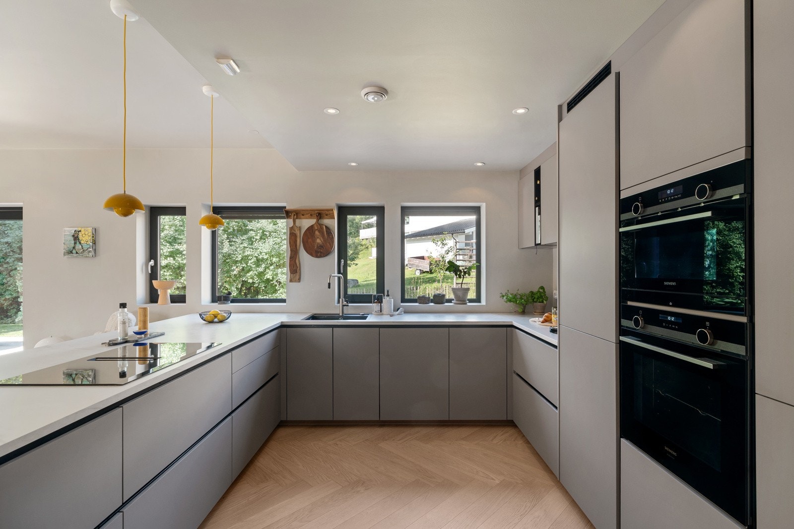 Kjøkkenet er i en lekker grå farge med hvit benkeplate. Galleribilde