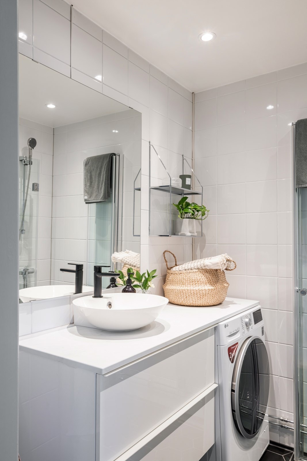 Badet er flislagt med varmekabler i gulv, og har praktisk innredning med god oppbevaringsplass og opplegg for vaskemaskin. Galleribilde