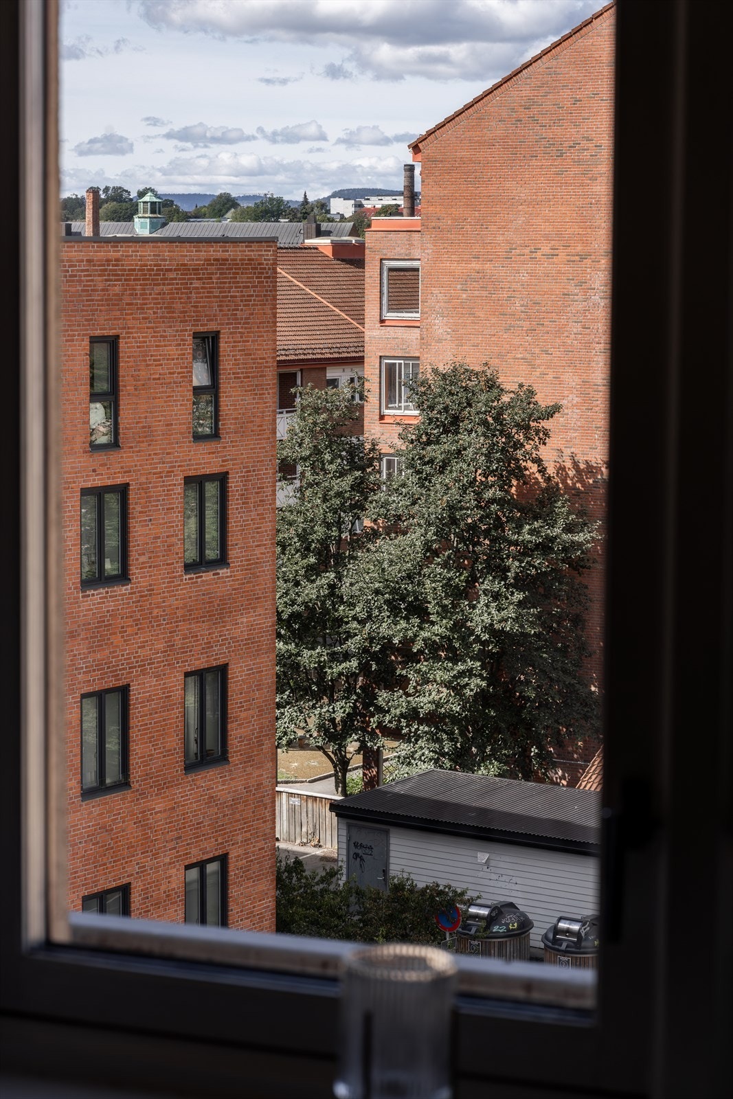 Fra vinduet har du et hyggelig utsyn over nærområdet, med både grønne trær og klassiske teglsteinsbygg - et fint blikkfang i hverdagen. Galleribilde