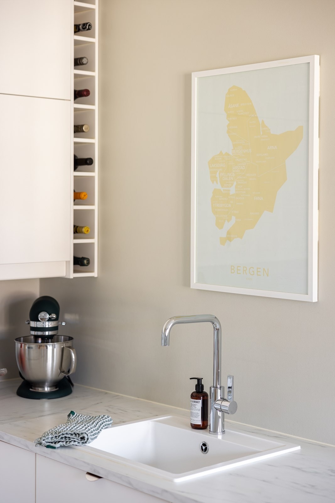 Vinhyllen gir praktisk oppbevaring og passer fint inn i den stilrene kjøkkenløsningen. Galleribilde