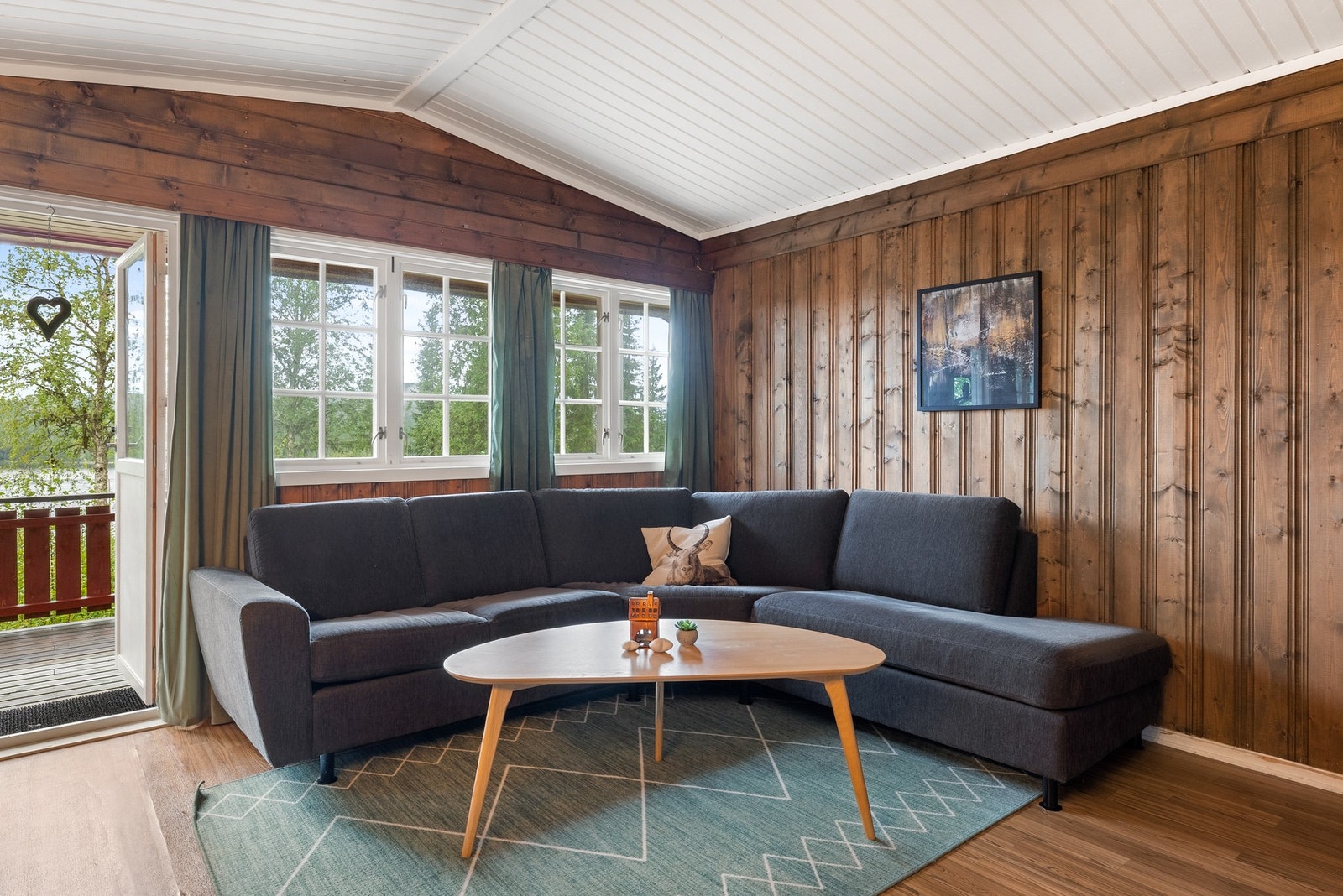 Stuen oppleves lys og trivelig. Vinduene rammer inn den frodige utsikten Galleribilde