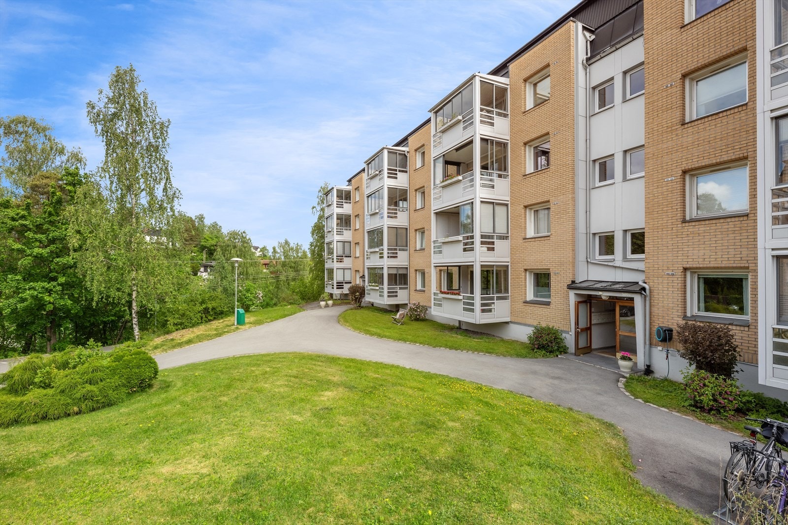 Det er grønne plener, pen beplantning, sykkelparkering og asfalterte internveier mellom blokkene. Galleribilde