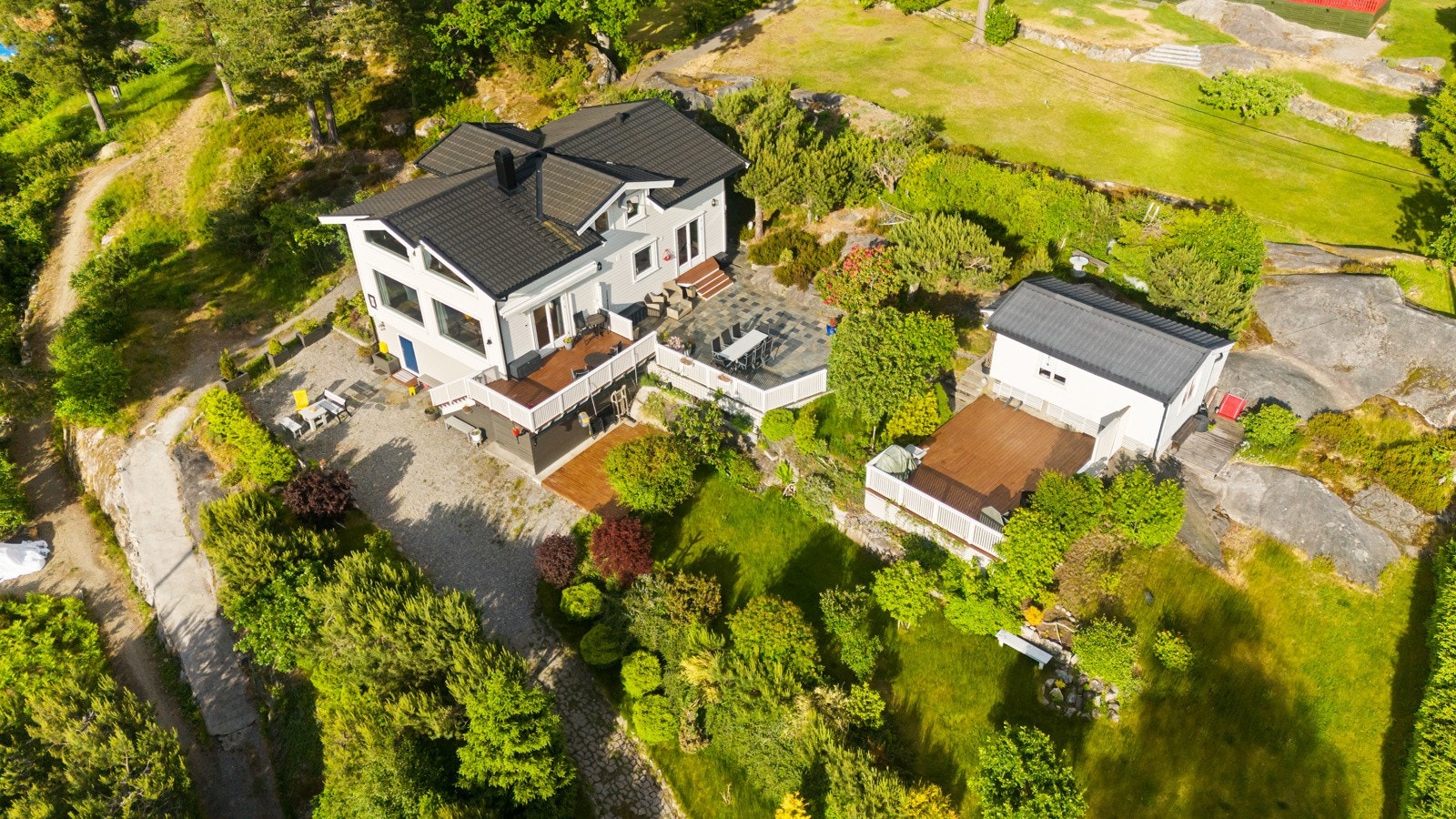 Eiendommen er på hele 1,5 mål og tilbyr flere soner og store plenarealer. Galleribilde