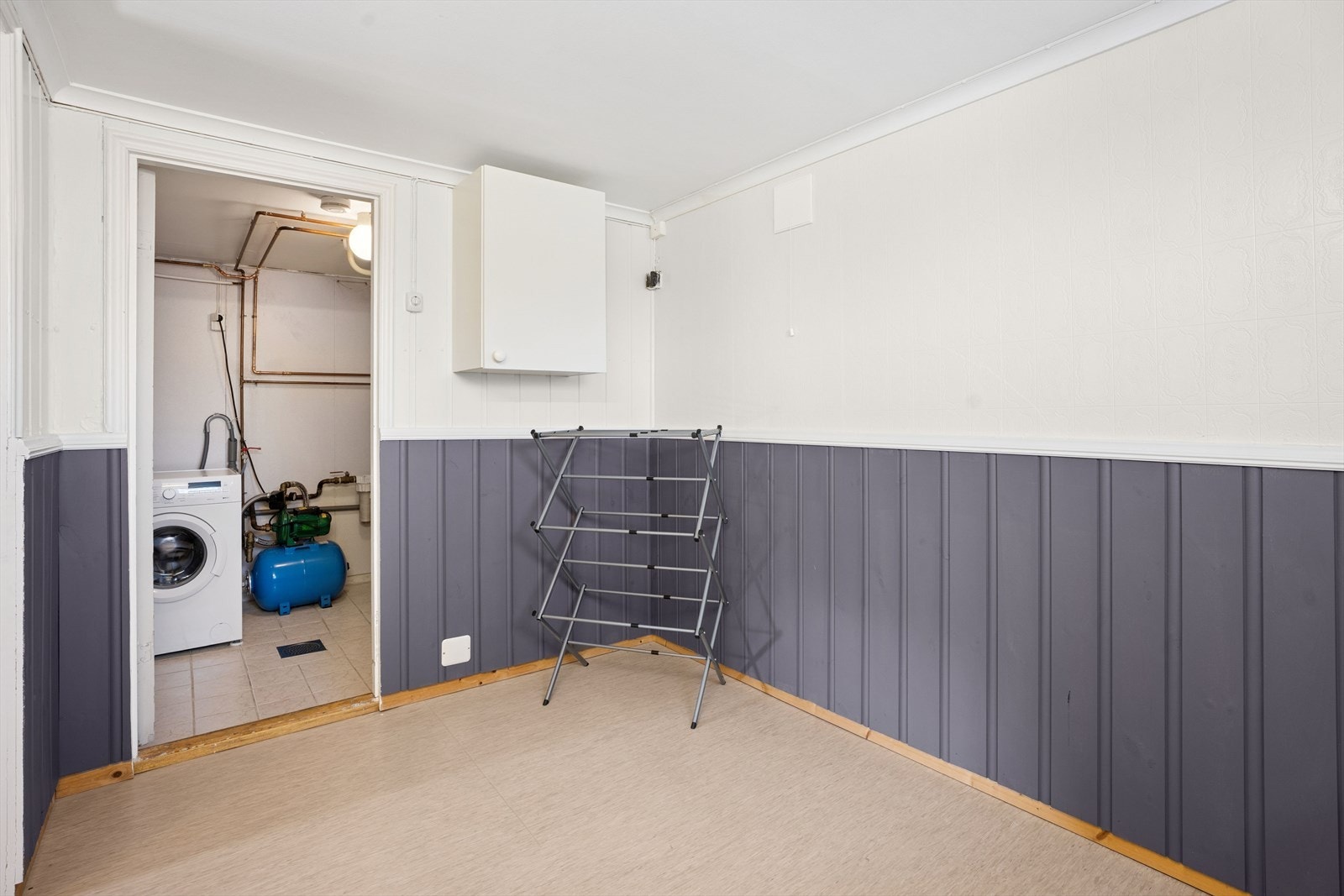 Rett ved kjellerens gang/entre finner man vaskerommet. Et stort og godt bruksrom med benk og skap i ene enden, samt godt med gulvareal til å henge opp klesvasken. Galleribilde