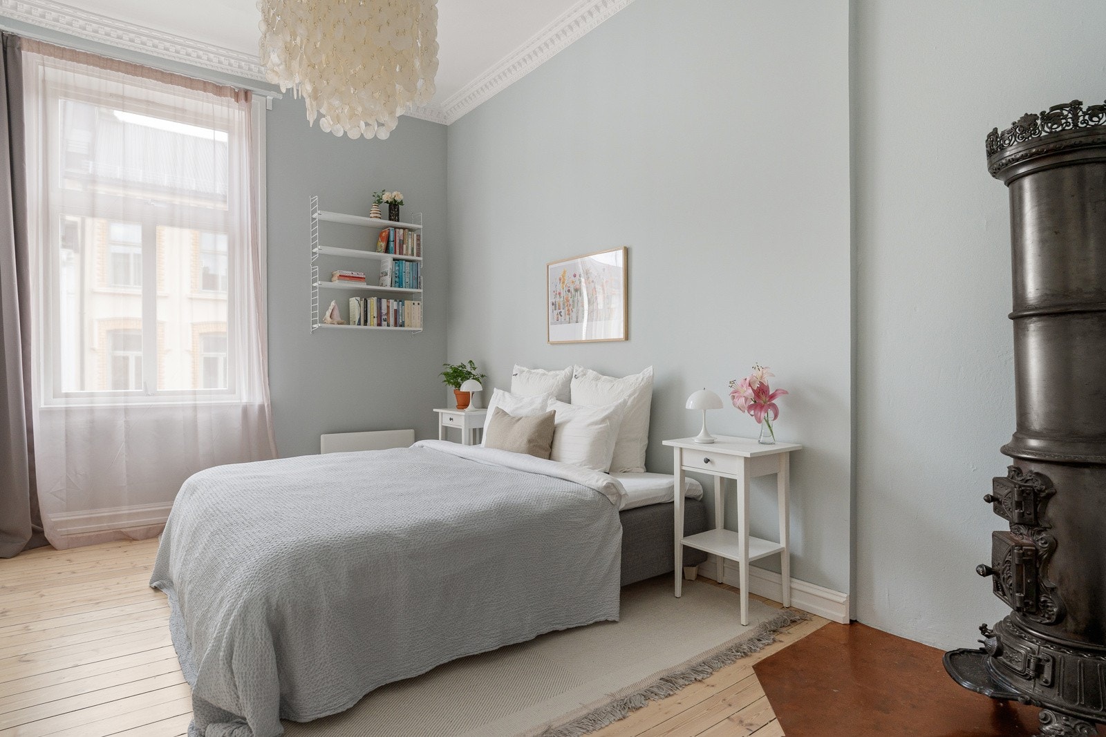 Lyst og luftig soverom med rikelig oppbevaringsmuligheter. Nydelig klassisk støpejernsovn er som et smykke i rommet. Galleribilde