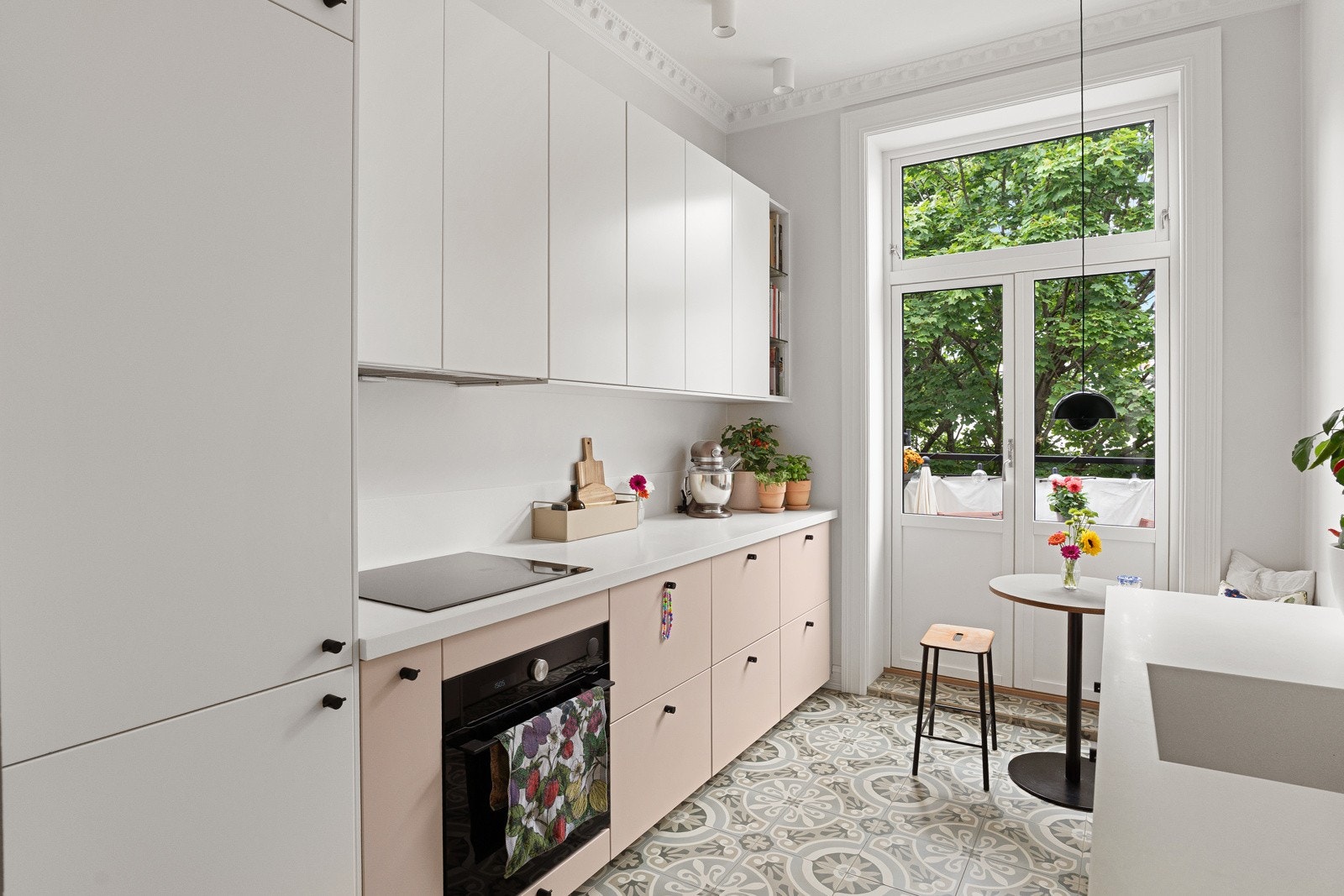 Pen kjøkkeninnredning med slette fronter, overskap med benkebelysning og backsplash plater Galleribilde