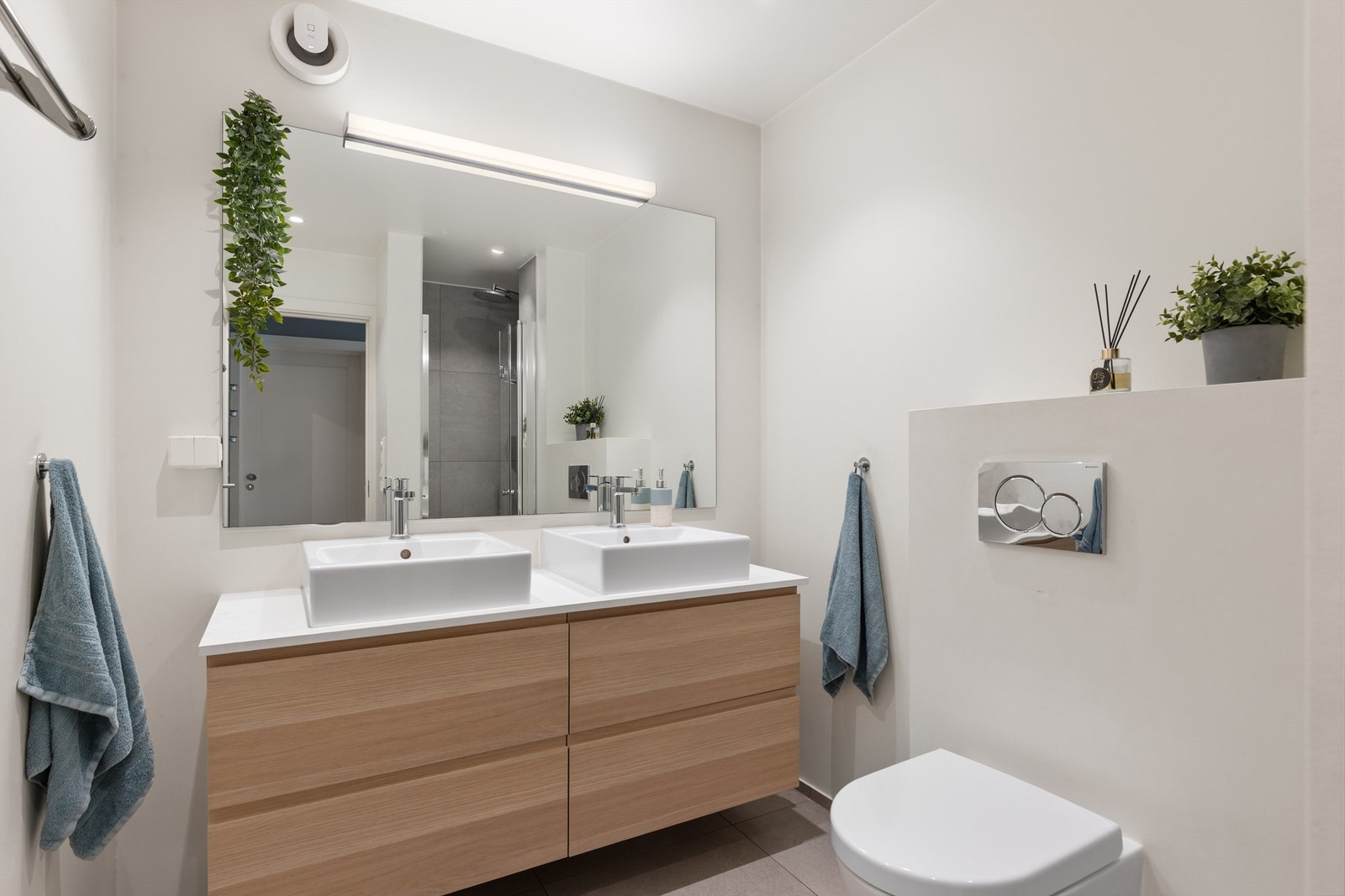 Delikat baderom fra 2017 med flislagt gulv med gulvvarme. Praktisk med dobbel servant samt oppbevaringsplass i servantskuffer Galleribilde