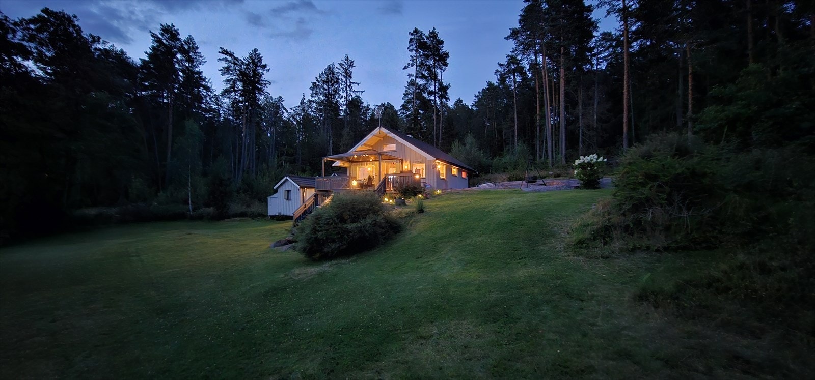 Selgers eget bilde av eiendommen på kveldstid. Galleribilde