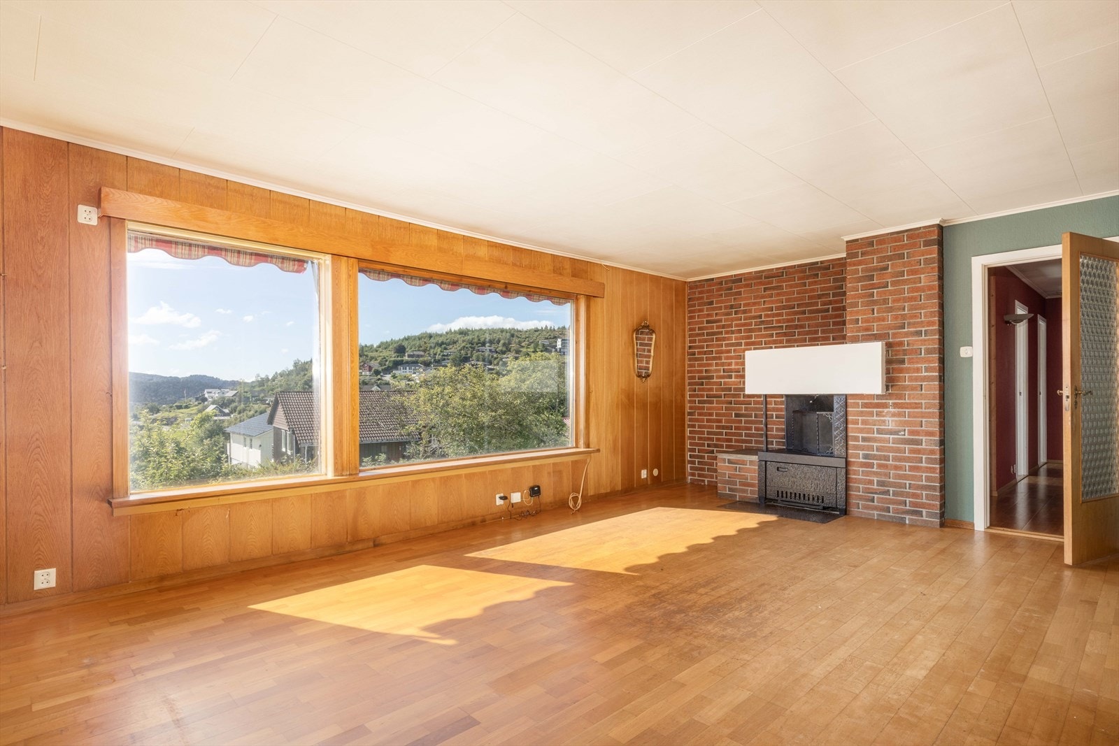 Rommet har flere store vinduer som gir godt med naturlig lys, og en utsikt som en virkelig lar seg beundre av. I hjørnet av stuen finner du en herlig peis. Perfekt for kaldere dager. Galleribilde