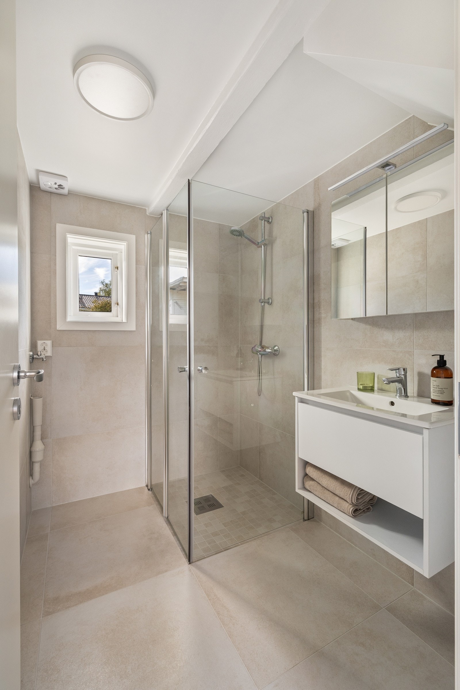 Boligen har et nyrenovert baderom fra 2025 i moderne stil. Tiltalende 60x60 fliser på gulv og vegger. Galleribilde