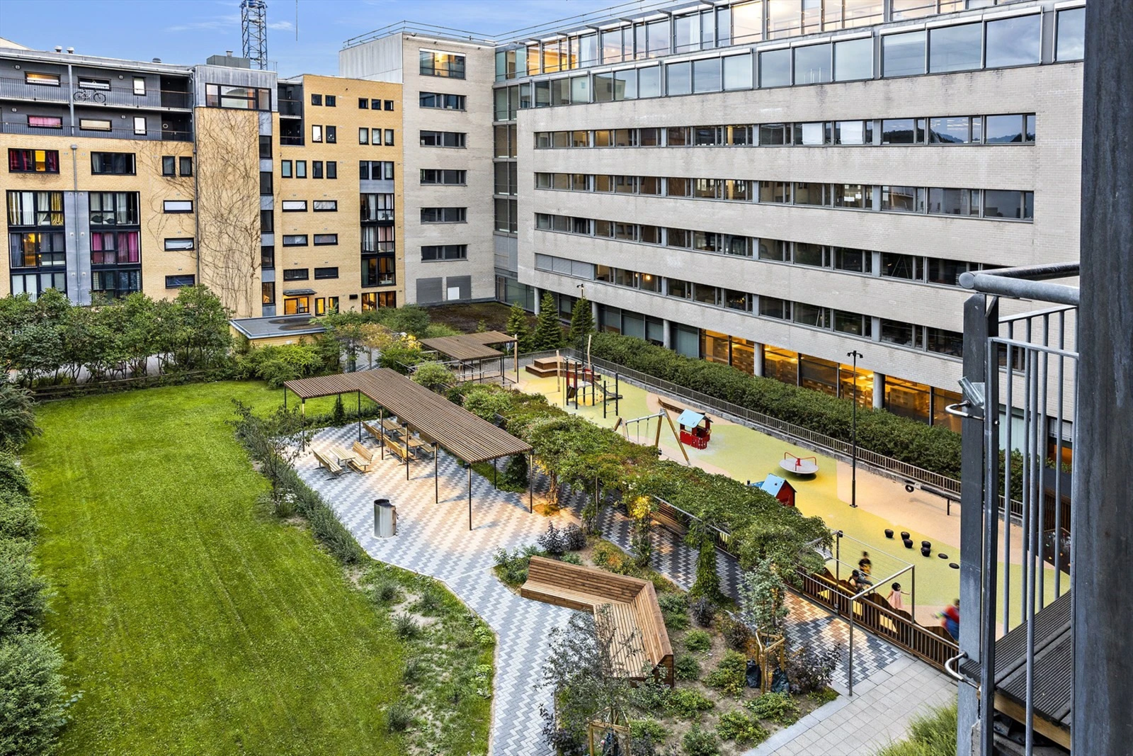 Bakgården har en lekeplass, ulike sittegrupper og grøntområder. Galleribilde