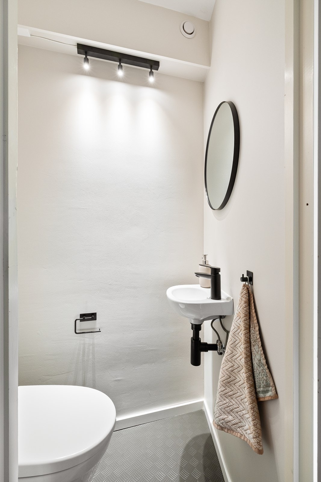 Toalettrommet har belegg på gulvet, toalett og håndvask med speil over. Galleribilde