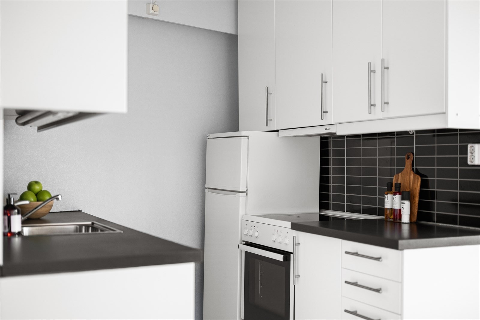 Kjøkkenet er i hvit innredning med glatte fronter og benkeplate i laminat. Galleribilde