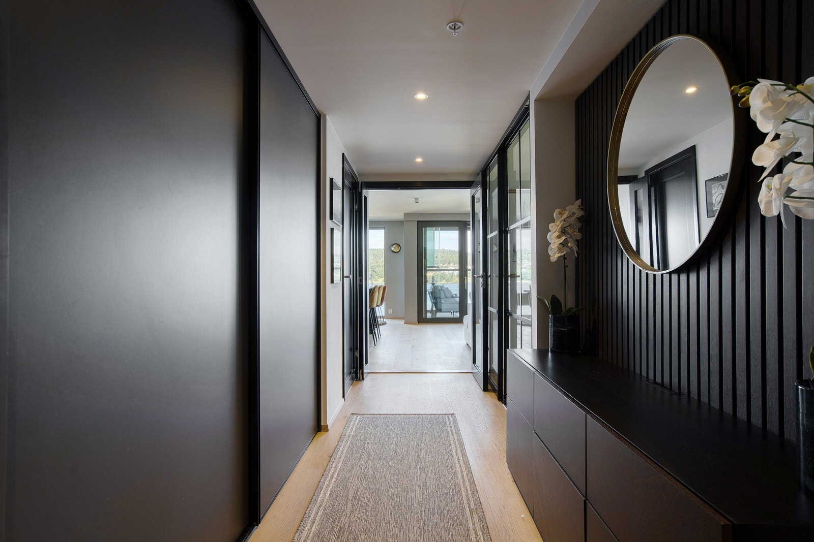 Den romslige hallen gir et svært godt førsteinntrykk og er smakfullt innredet med sort spilevegg og skyvedørsgarderobe fra Drømmekjøkken. Galleribilde