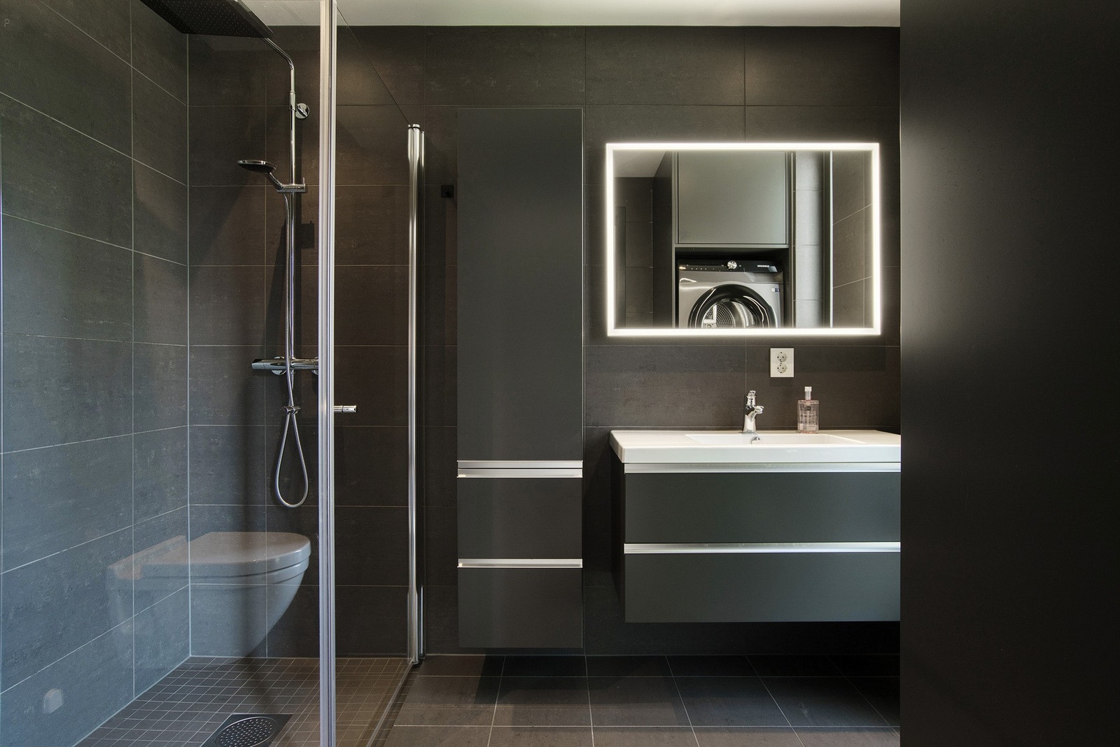 Badet er innredet med servant, dusjhjørne. vegghengt toalett og høyskap. Galleribilde