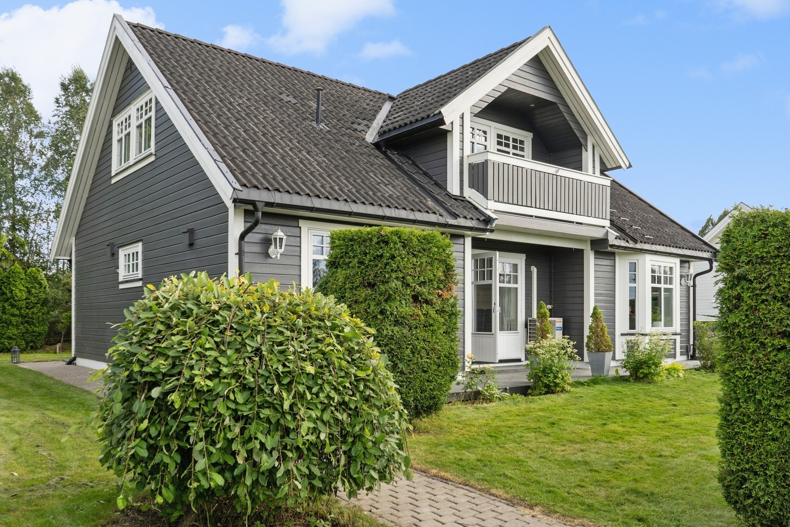 Eiendommen er pent opparbeidet med belegningsstein og en skjermende hekk. Galleribilde