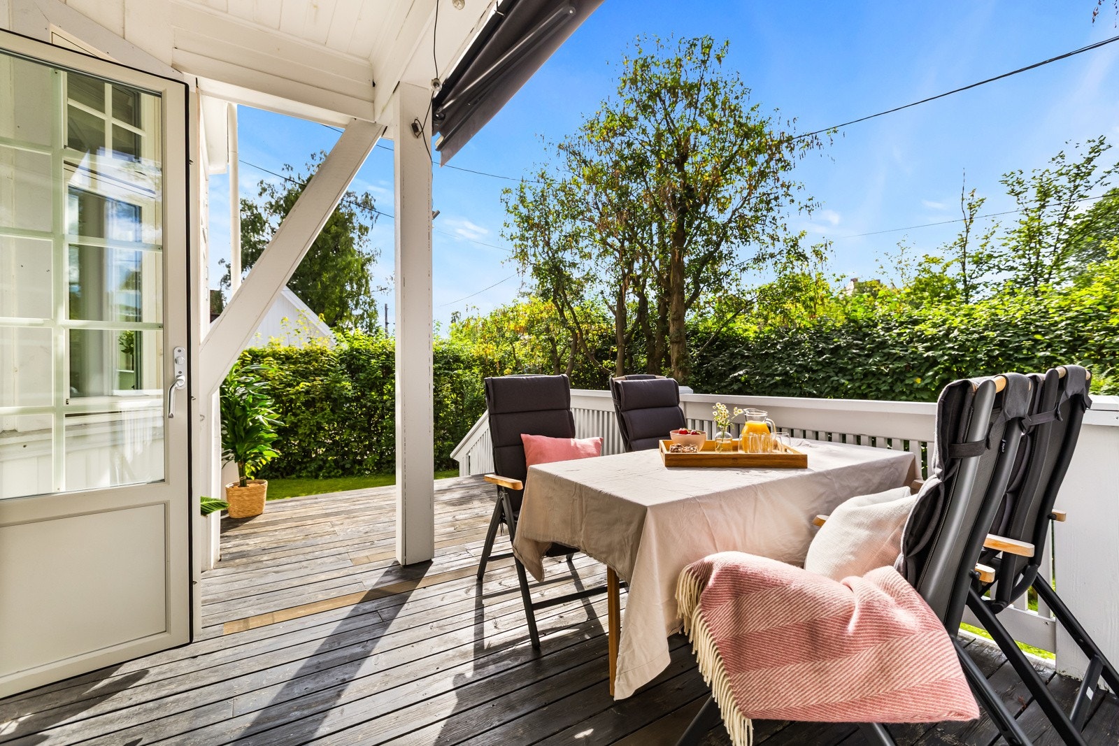 Romslig og delvis overbygget terrasse på oppunder 21 kvm med god plass til spisegruppe, omkranset av en frodig hage. Galleribilde