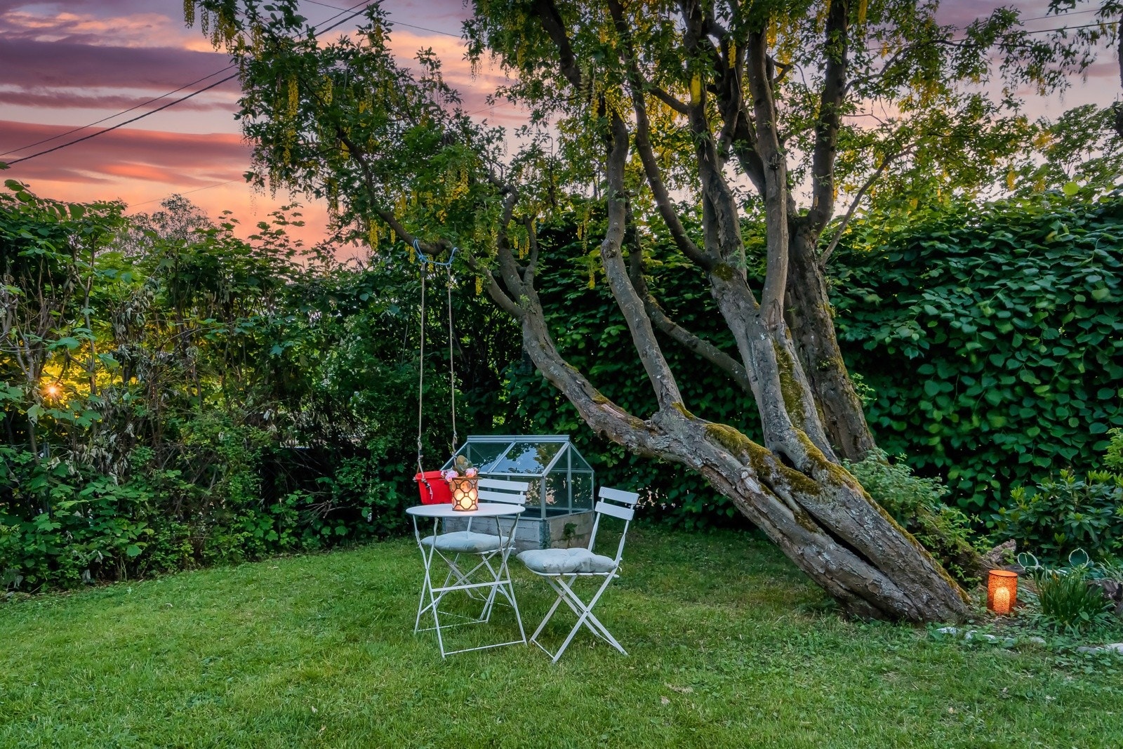 Sjarmerende hagehjørne med sittegruppe og liten huske - et koselig sted for både små og store. Galleribilde