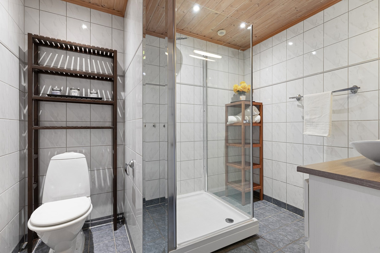 Flislagt bad med gulvvarme. Innredet med gulvstående toalett, dusjkabinett og servantskap Galleribilde