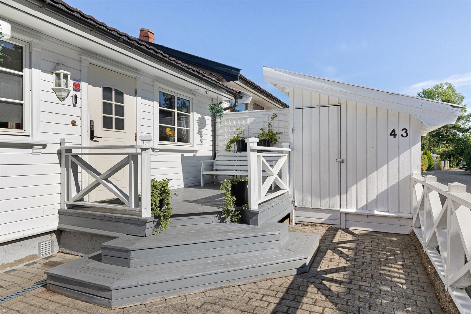 Steinlagt gårdsplass med en hyggelig adkomst og bod utenfor døren Galleribilde